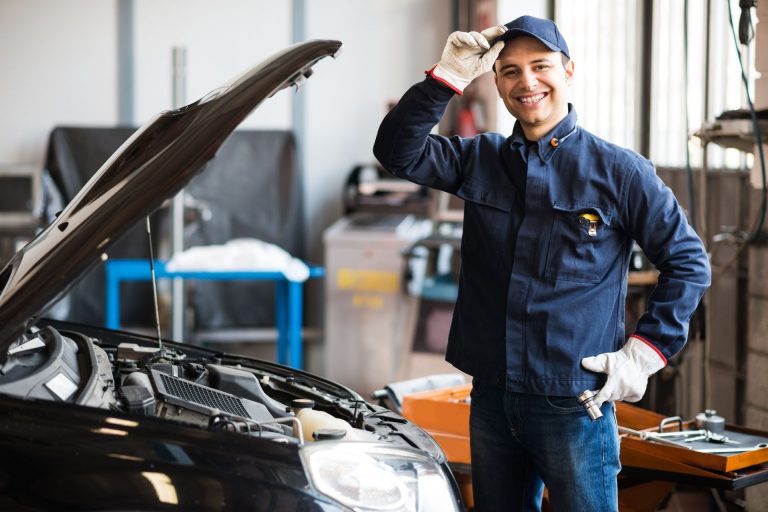 smiling technician in car workshop